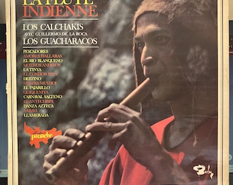 Puede incluir: Portada de álbum de vinilo vintage titulada "La Flute Indienne" con un hombre tocando la flauta. La portada tiene texto en francés y español, con una combinación de colores marrón y rojo. El álbum es de Los Calchakis y Los Guacharacos.