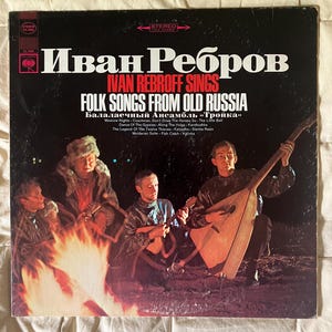 May include: A vintage vinyl record album cover featuring Ivan Rebroff and the text "Ivan Rebroff Sings Folk Songs From Old Russia." The cover shows a group of men around a bonfire, with one playing a large stringed instrument.