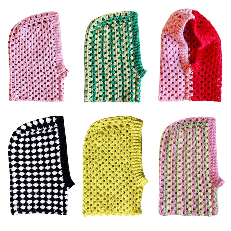 Op de afbeelding: Zes gebreide mutsen in verschillende kleuren en patronen. De mutsen zijn allemaal gemaakt met een vergelijkbare steek en hebben een puntige kap. De kleuren omvatten roze, groen, rood, zwart, geel en een combinatie van roze en groen.