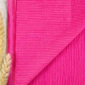 May include: A vibrant hot pink fabric featuring a distinct, fine horizontal ribbed texture. The material is folded to reveal its consistent color and surface pattern, showcasing a bright, saturated hue throughout the entire textile piece.