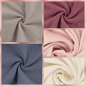 Könnte beinhalten: Eine Sammlung von fünf Stoffmustern mit einer weichen, gefilzten Textur. Die Farben umfassen ein neutrales Beige, ein tiefes Pflaume, ein zartes Pastellrosa, ein gedämpftes Schieferblau und ein cremiges Off-White, angeordnet in einem Raster.