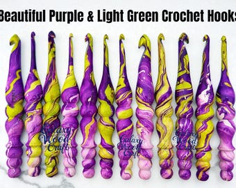 May include: A set of crochet hooks in purple and light green, featuring a marbled pattern. The hooks are displayed upright, highlighting their individual, swirling designs. The text "Beautiful Purple & Light Green Crochet Hooks" is at the top.