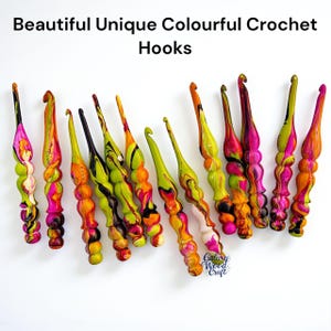 Puede incluir: Una colección de coloridas agujas de ganchillo con efecto veteado. Las agujas presentan una variedad de colores vibrantes, incluyendo rosa, naranja, amarillo y verde. El texto "Beautiful Unique Colourful Crochet Hooks" está en la parte superior de la imagen.