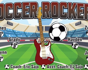Puede incluir: Un banner de equipo de fútbol con las palabras "Soccer Rockers" en letras rojas y negras. El banner presenta una guitarra eléctrica roja con una placa de protección blanca y un balón de fútbol. La lista del equipo incluye nombres y números: James 6, Zeke 3, Grady 8, Hayden 4, Elwynn 7 y Jude 5. El banner también incluye los nombres de los entrenadores: Eric Sajo y EJ Sajo.