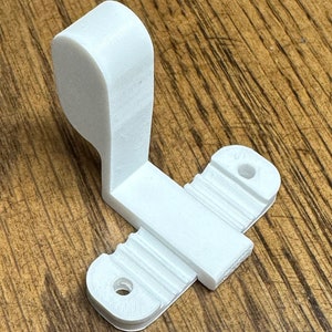May include: White plastic 3D printed hook with two holes and a textured surface. The hook is designed to be mounted on a wall or other surface.