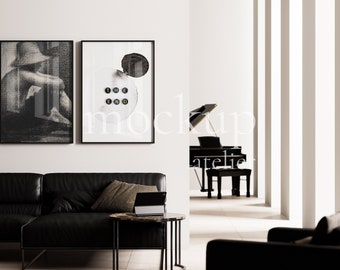 May include: Two framed art prints with black frames hang on a white wall. One is a black and white sketch of a person. The other has a white background with black shapes and the words "THE END". A black leather sofa and a round table are in the foreground.