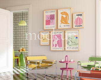 Op de afbeelding: Een woonkamerinterieur met een geel, groen en oranje kleurenschema. De kamer heeft een set van vier ingelijste kunstprints met abstracte ontwerpen en de tekst "Picasso" en "H. Matisse". De kamer heeft ook een roze bijzettafel met twee kopjes en een gele stoel.
