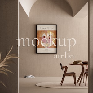 Puede incluir: Una impresión de arte enmarcada de una pintura de Paul Klee, titulada "El pájaro con el pico dorado", cuelga de una pared beige en un interior moderno. La impresión está en un marco negro y presenta formas abstractas en tonos de amarillo, rojo y rosa.