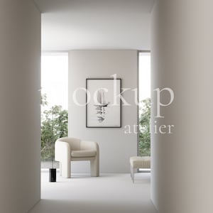 May include: A white armchair with a black frame sits in a minimalist living room with a framed watercolour painting of a sailboat on the wall. The room has large windows with a view of trees outside.