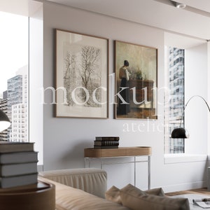 Puede incluir: Un salón moderno con un sofá blanco, una lámpara de pie negra y una consola con libros y una lámpara. Dos impresiones de arte enmarcadas cuelgan de la pared. La habitación tiene grandes ventanas con vistas a un horizonte urbano.
