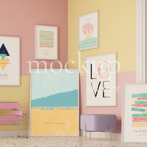 Puede incluir: Cinco impresiones de arte enmarcadas con varios diseños abstractos y texto, incluyendo "fields to oceans" y "may be balanced", mostradas en una pared rosa y amarilla con una silla rosa y un otomano morado.