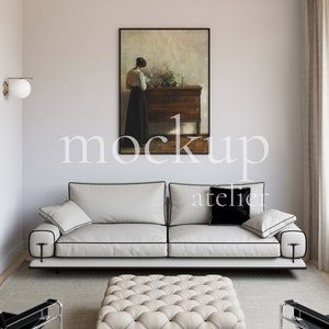 Könnte beinhalten: Ein weißes Sofa mit schwarzem Besatz und schwarzen Kissen steht in einem Wohnzimmer mit einem gerahmten Gemälde an der Wand, einem weißen Hocker vor dem Sofa und einem Fenster mit schwarz-weißen gemusterten Kissen auf der Fensterbank.