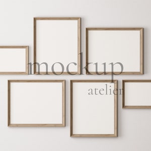 Puede incluir: Cinco marcos de fotos de madera de diferentes tamaños están dispuestos en una pared blanca. Los marcos están todos vacíos y tienen un acabado de madera natural. La palabra "mockup" está escrita en texto negro en la pared.