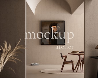 May include: A black framed painting of a man in a dark hat and clothing hangs on a beige wall in a modern living room. The painting is titled "atelier".