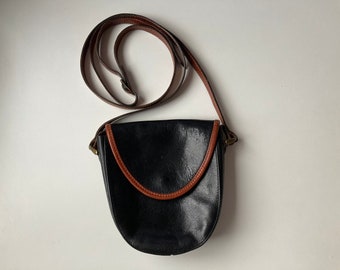 Bolsa transversal vintage La Vista | Preta e marrom canela | Fechamento magnético com aba frontal | 1 compartimento e 1 bolso | Parcialmente em couro legítimo