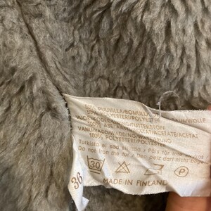 May include: A white tag with black text and symbols. The tag says "50% PUUVILLA/BOMULLUCO 50% POLYESTER/POLYESTER BAUMWOLLE 1VUORDEODER LINING/FUTTERSTOFF 100% ASETAATTACETAT/ACETATE/ACETAT VANU/VADD/WADDING/WANTIERUNG 100% POLYESTERI/POLYESTER Turkista el saa sit&auml;&auml; Pals f&ouml;r intewukas/ Do not fron the fur/ Der peiz dari nicht buge 36 30 MADE IN FINLAND P"