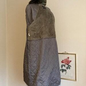 May include: A gray quilted jacket with a faux fur collar. The jacket is lined with a soft, fuzzy material.
