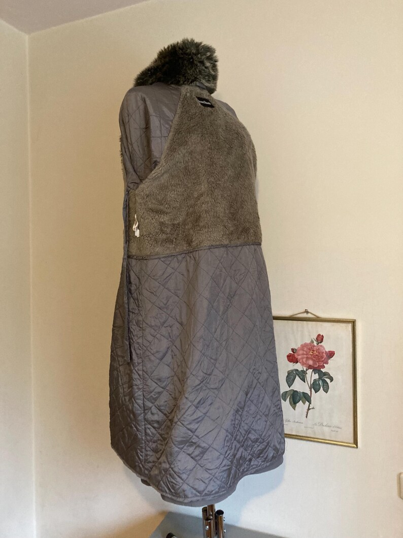 May include: A gray quilted jacket with a faux fur collar. The jacket is lined with a soft, fuzzy material.