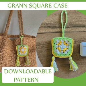 Op de afbeelding: Een gehaakt granny square-hoesje met een groen, wit en geel bloemenmotief. Het hoesje is bevestigd aan een wit koord met kwastjes. Het hoesje wordt getoond naast een wit AirPod-hoesje op een houten oppervlak. De tekst "DOWNLOADABLE PATTERN" staat onderaan de afbeelding.