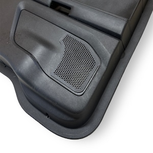 Könnte beinhalten: Nahaufnahme eines schwarzen Autotürpanels mit einem Lautsprechergitter. Das Gitter besteht aus einem schwarzen Netzmaterial und befindet sich in der unteren rechten Ecke des Panels.