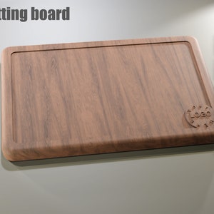 Puede incluir: Tabla de cortar rectangular de madera con borde empotrado. La tabla tiene un patr&oacute;n de vetas de madera natural y un logotipo circular en la parte inferior derecha. El texto "Cutting board" est&aacute; en la parte superior. Iconos de tipo de archivo a la derecha.