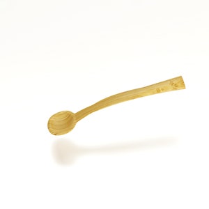 May include: A wooden spoon with a rounded bowl and a long, slender handle. The spoon is made of light brown wood and has a natural finish.