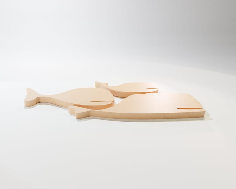 Puede incluir: Tres recortes de ballenas de madera de diferentes tama&ntilde;os. Las ballenas son de madera de color claro y tienen un dise&ntilde;o simple y minimalista. La ballena m&aacute;s grande mide aproximadamente 30 cm de largo, siendo las otras dos m&aacute;s peque&ntilde;as.