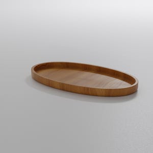 May include: A wooden, oval-shaped tray with a smooth, polished surface. The tray is made of light brown wood and has a slightly raised edge. The design is simple and modern, suitable for serving or display.