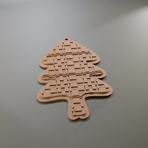 May include: A wooden Christmas tree ornament with a unique, layered design. The tree is light brown with a grid-like pattern cut into the wood. It has a small hole at the top for hanging. The ornament is a festive decoration.