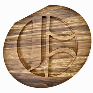 May include: A wooden serving tray with a carved design. The tray is oval-shaped with a dark brown finish and visible wood grain. The carved design features the letters "J" and "B" in a stylized font. The tray is approximately 12 inches in diameter.