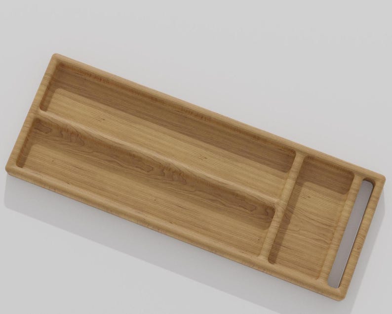 K&ouml;nnte beinhalten: Ein rechteckiges Holztablett mit drei F&auml;chern und einem Griff. Das Tablett besteht aus hellem Holz mit sichtbarer Maserung. Die F&auml;cher sind durch erh&ouml;hte Trennw&auml;nde getrennt, und der Griff ist ein Ausschnitt an der Seite.