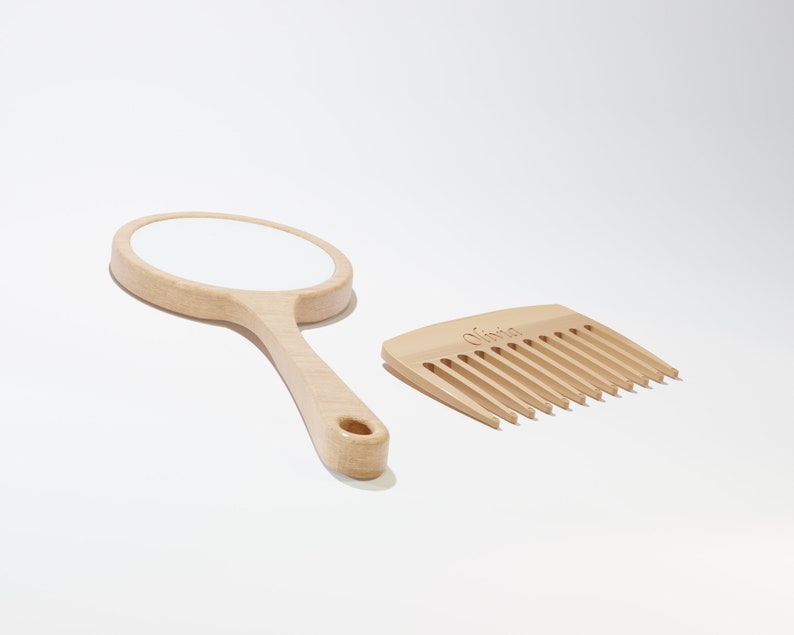 A round wooden hand mirror on the left and a wooden comb on the right
