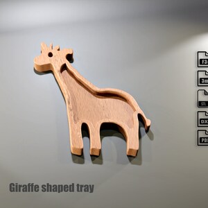 May include: A wooden tray in the shape of a giraffe. The tray is light brown with a recessed area for holding items. The text "Giraffe shaped tray" is at the bottom of the image.
