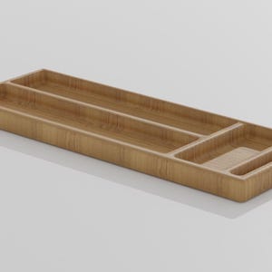 K&ouml;nnte beinhalten: Ein rechteckiger Organizer aus hellem Holz mit mehreren F&auml;chern. Das Holz hat eine glatte Oberfl&auml;che und verf&uuml;gt &uuml;ber lange, schmale Abschnitte sowie kleinere F&auml;cher. Die L&auml;nge betr&auml;gt ca. 30 cm.