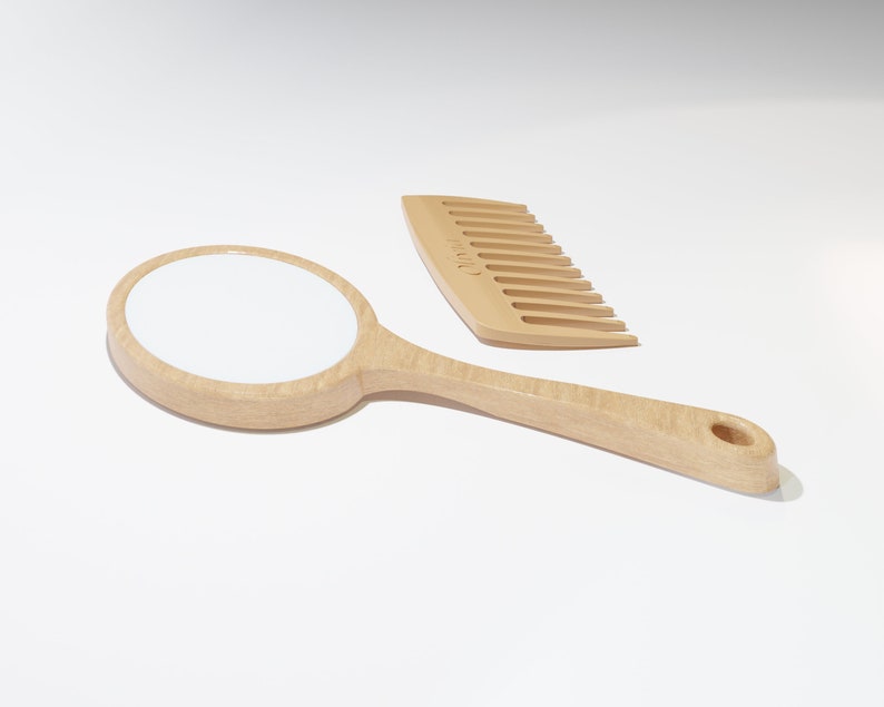 A round wooden hand mirror on the left and a wooden comb on the right