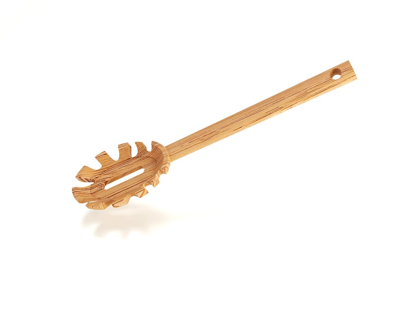 Puede incluir: Un servidor de pasta de madera con un mango largo y un dise&ntilde;o &uacute;nico y dentado. El servidor est&aacute; hecho de madera natural y tiene un color marr&oacute;n claro.