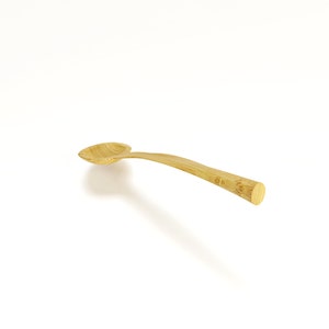 May include: A wooden spoon with a natural finish. The spoon has a rounded bowl and a long, slender handle.