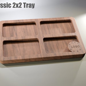 Puede incluir: Bandeja de madera con cuatro compartimentos rectangulares y un &aacute;rea circular para un logotipo. La bandeja tiene un acabado de vetas de madera marr&oacute;n oscuro y una base negra. El texto "Classic 2x2 Tray" est&aacute; en la parte superior.