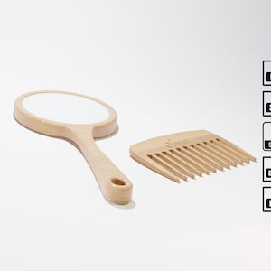 Puede incluir: Un espejo de mano de madera con una superficie reflectante redonda y blanca y un peine de madera con la palabra "Olivia" grabada en él. El peine tiene 10 dientes.