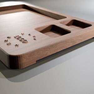 Pu&ograve; includere: Un vassoio in legno dal design rettangolare, con un'ampia area incassata e due sezioni incassate pi&ugrave; piccole. Il vassoio ha bordi arrotondati e una finitura naturale venata del legno. La parola "LOGO" &egrave; intagliata nel legno.