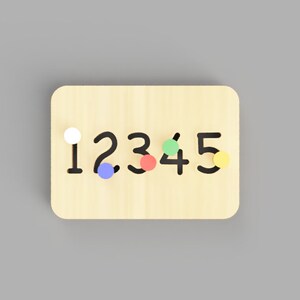 May include: Wooden number puzzle board with the numbers 1 to 5 in black. Each number has a corresponding coloured peg: white, blue, red, green, and yellow. The board is made of light-coloured wood.