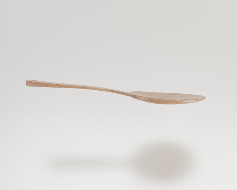 May include: A light-colored wooden spoon with a long, curved handle and a wide, oval bowl. The spoon is made of a light-colored wood, possibly maple or birch, and has a smooth, natural finish. The spoon is designed for cooking and serving.
