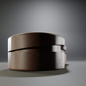 May include: A round, wooden box with a dark brown finish. The box has a unique design with a horizontal cut across the middle and a layered side detail. The wood grain is visible, adding texture. The box sits on a light gray surface.