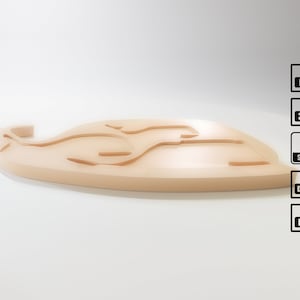 Puede incluir: Un objeto decorativo en forma de ballena, de color beige claro, con una serie de l&iacute;neas curvas y empotradas. El objeto est&aacute; sobre un fondo blanco. Se ven iconos de archivos F3d, 3mf, STL, DXF y PDF.