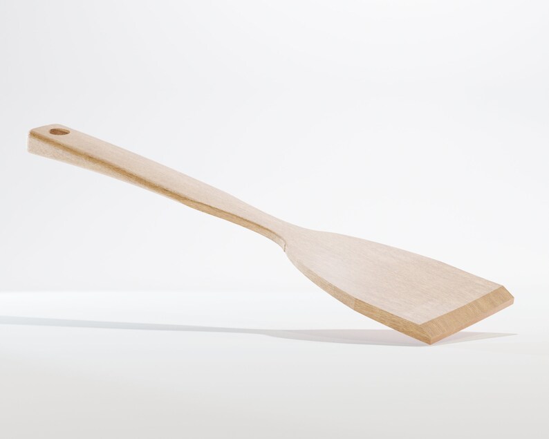 May include: A light-colored wooden spatula with a long handle and a flat, angled head. The spatula has a hole at the end of the handle for hanging. The kitchen utensil is made of a light-colored wood.