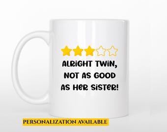 May include: White ceramic mug with a handle. The mug features the text "Alright Twin, Not as Good as Her Sister!" in black, with three yellow star icons. A yellow banner at the bottom reads "Personalization Available."
