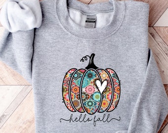 Puede incluir: Una sudadera gris con una calabaza estampada de colores y el texto "hello fall" impreso en la parte delantera.