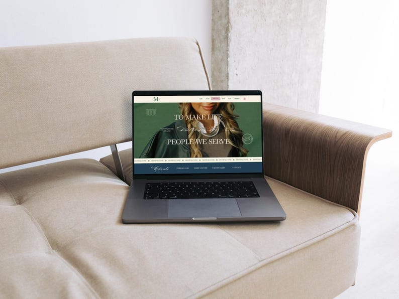 May include: A laptop displaying a website with the text "TO MAKE LIFE PEOPLE WE SERVE" sits on a beige sofa. The laptop is open, showing a website with a woman's image. The sofa is light beige, and the background is a neutral color.