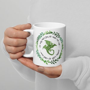 May include: White ceramic mug with a green dragon illustration and a green leafy wreath around the dragon. The text on the mug reads "...the only one for the green dragon... comes from the green dragon."