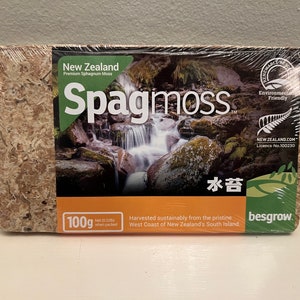 May include: A rectangular package of New Zealand Spagmoss, a premium sphagnum moss. The packaging features a waterfall scene and the text "Environment Friendly." It contains 100g (0.22 lbs) of moss, harvested sustainably from the West Coast of New Zealand's South Island.